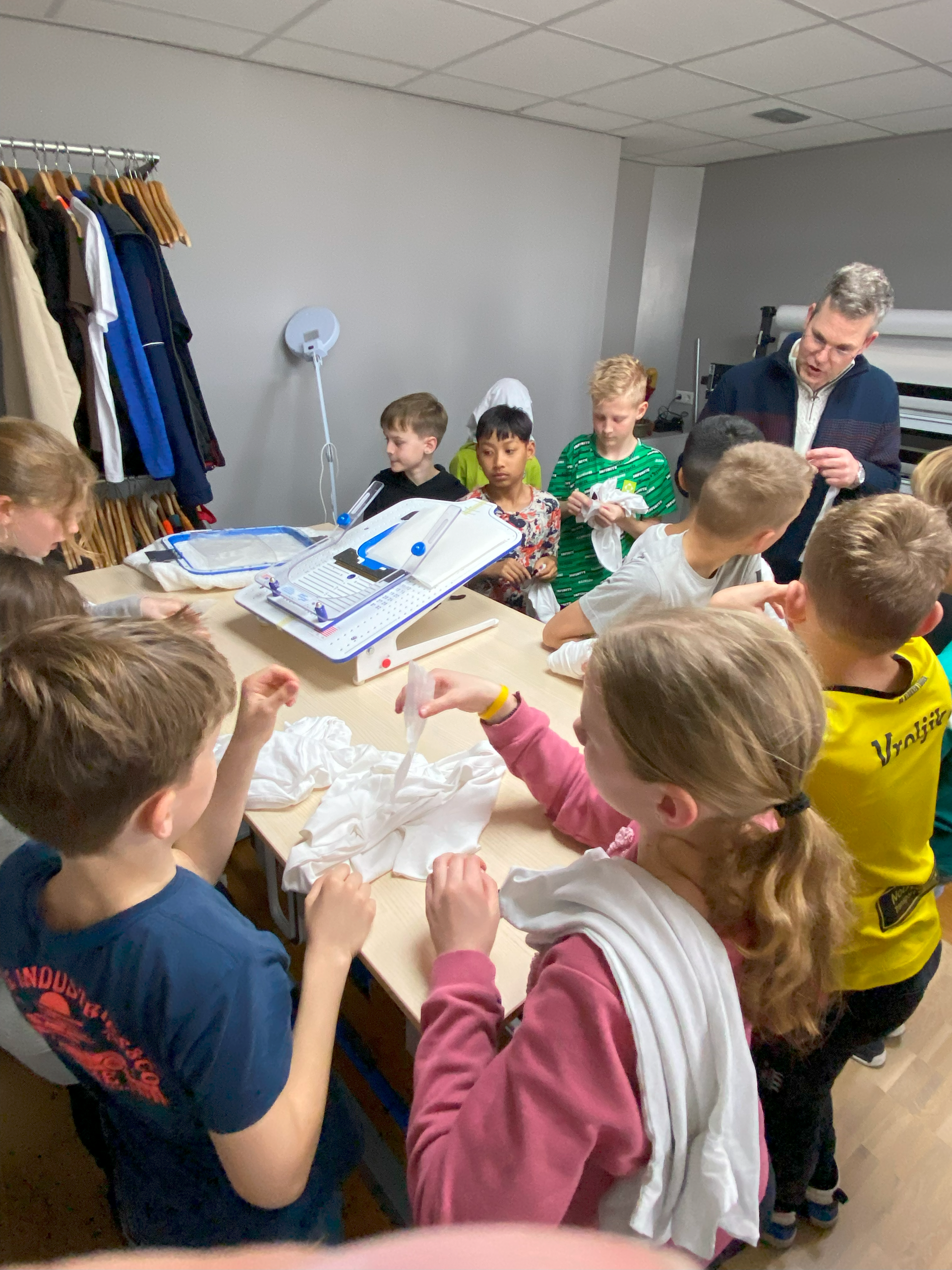 Een aantal kinderen uit een klas voelen welke materialen er nodig zijn bij het borduren van kleding