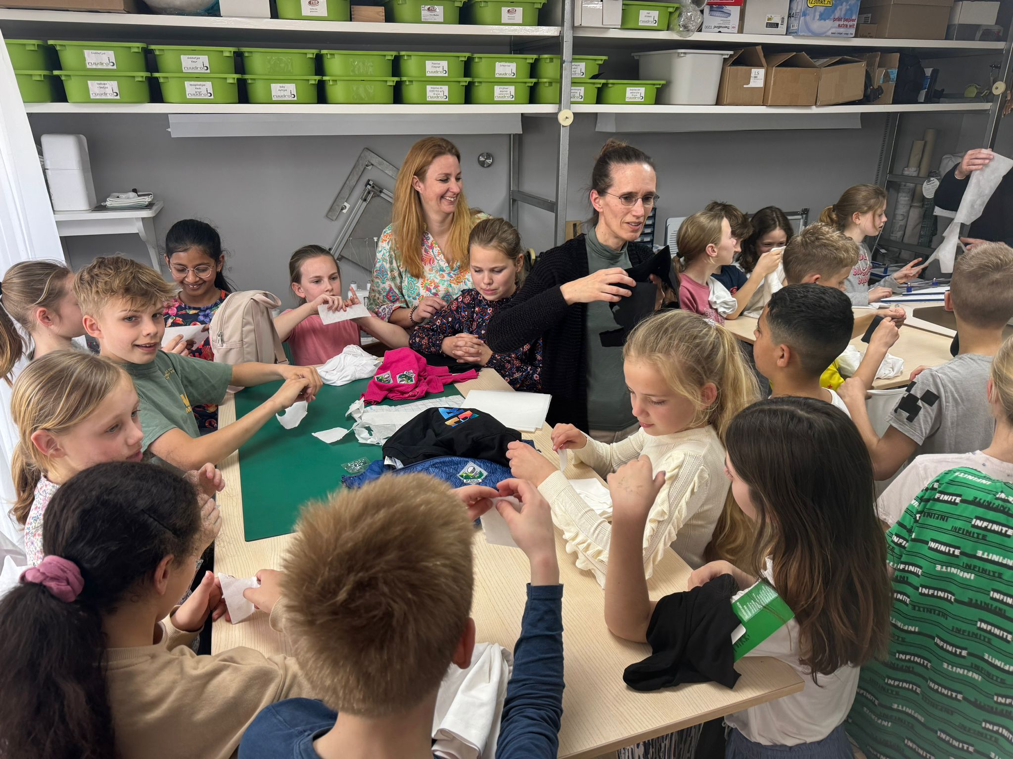 Schoolklas in het atelier luisterend en voelend en proberend kennismakend met de materialen